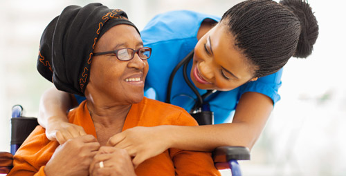 An older woman being hugged by a female nurse